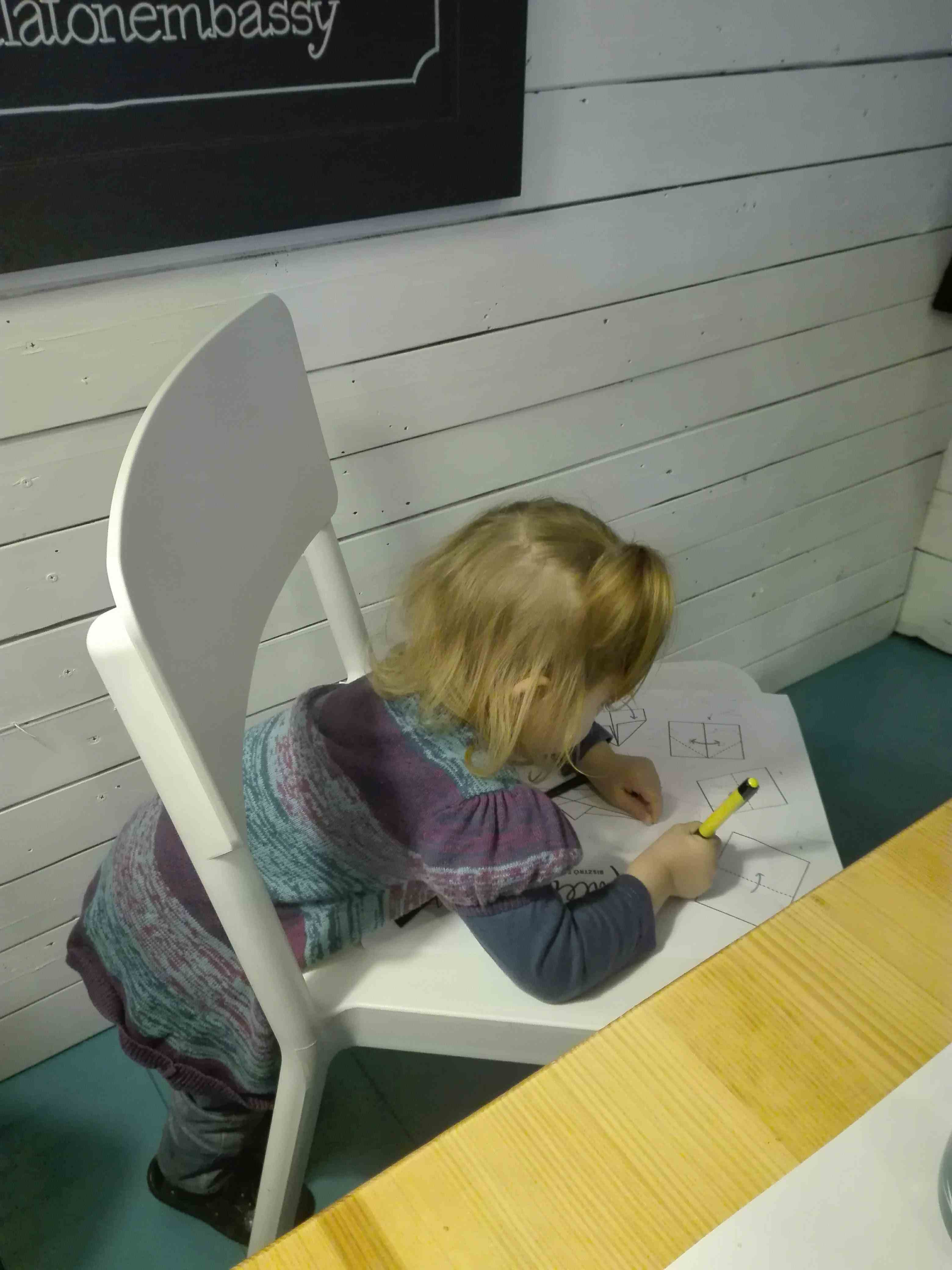Pixie draws at Paletta on the chair